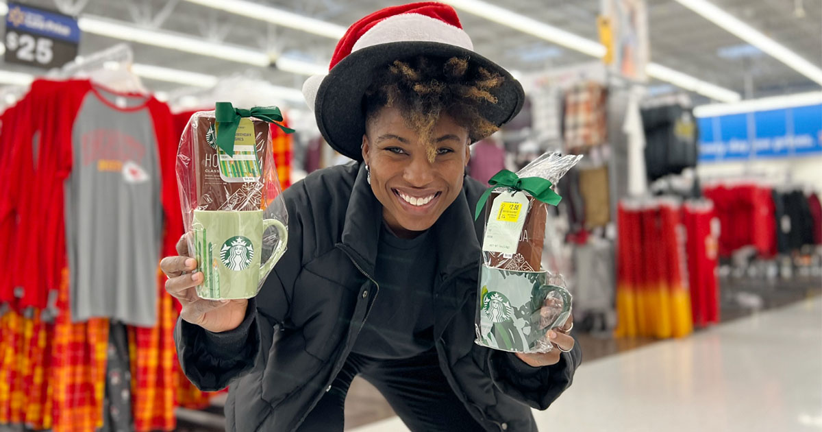 woman wearing a santa hat holding walmart starbucks gift sets