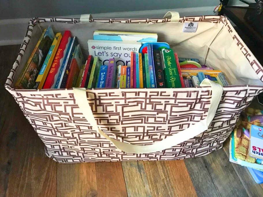 brown and white pattern large tote bag filled with books sitting on the floor