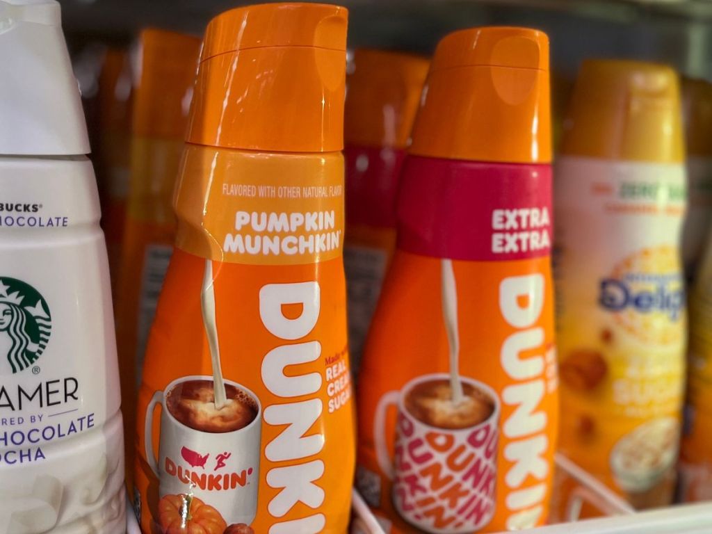 Refrigerator shelf filled with premade coffee creamers including starbucks, dunkin and international delight