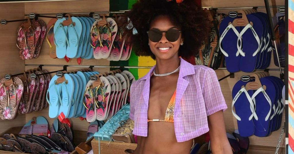 woman standing next to a Havaianas cart selling sandals and flip flops