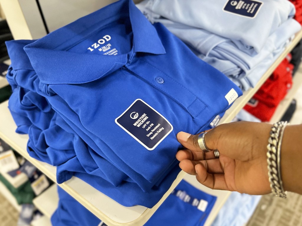 hand touching folded blue polo shirt