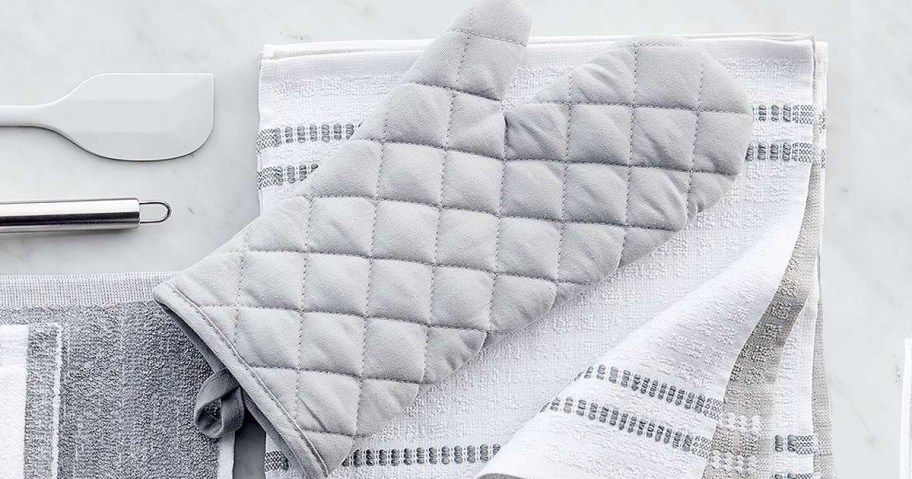 grey oven mitt on top of a stack of kitchen towels