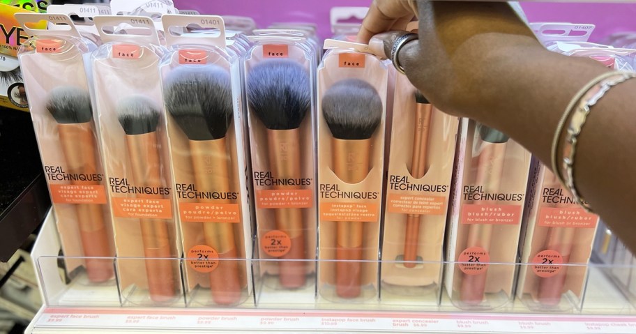 hand grabbing real techniques brush from store display