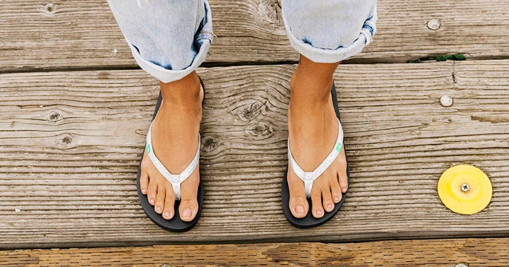 woman wearing silver flip flops