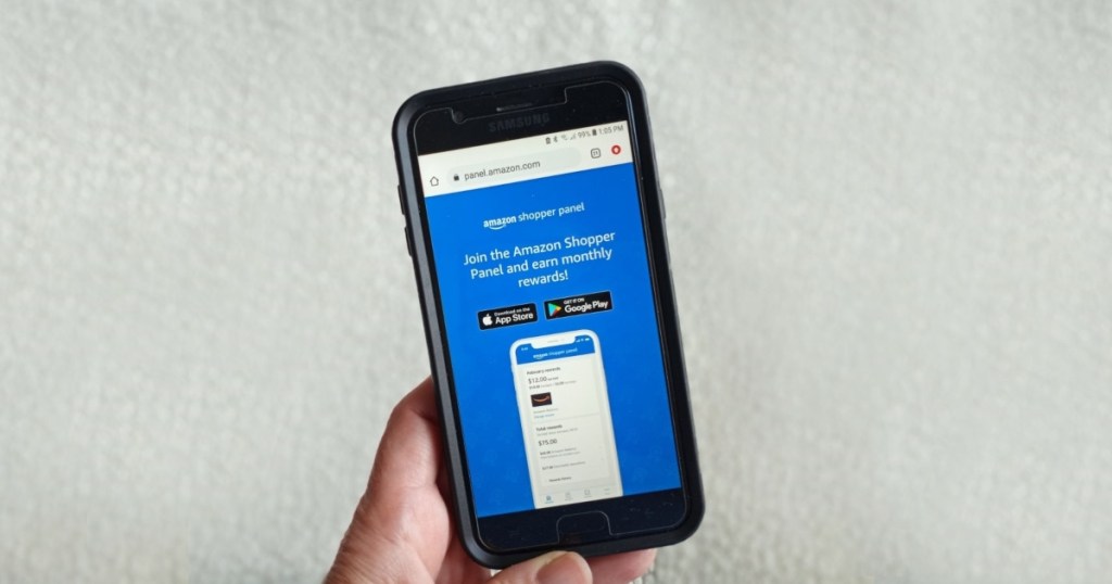 holding a phone showing the Amazon Shopper Panel app