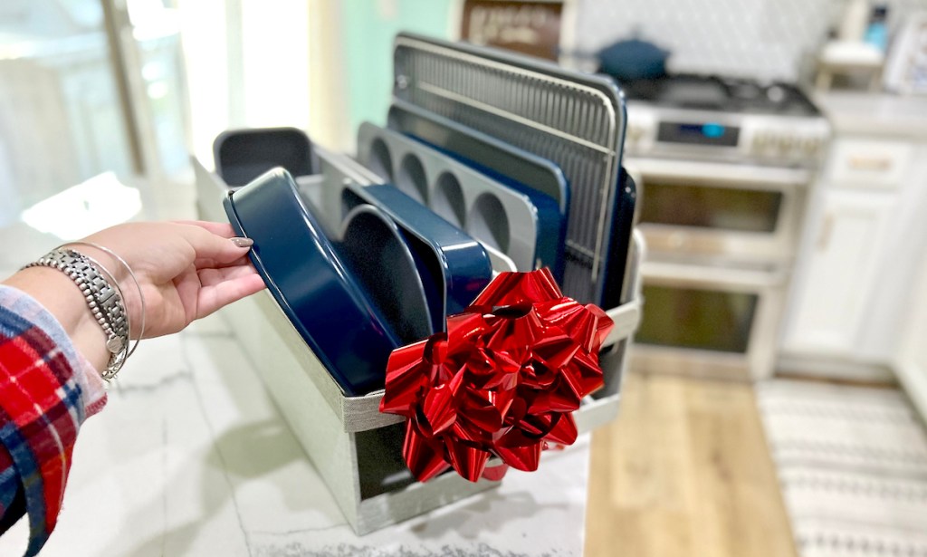 hand holding blue caraway bakeware set sitting on kitchen counter