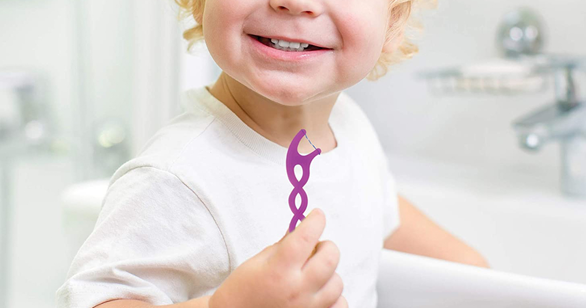 little boy with gum twistables flosser in hand 