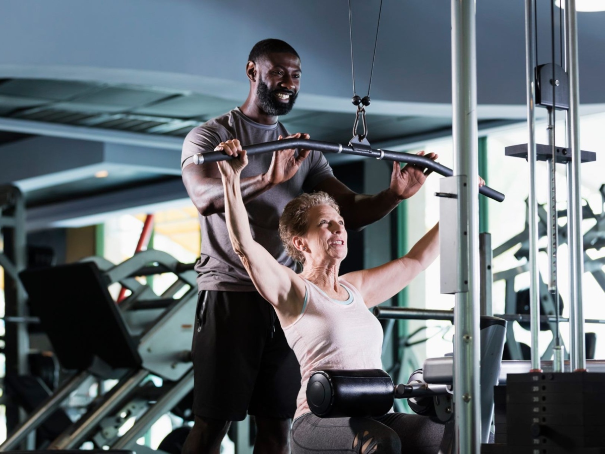 woman working with personal trainer at gym