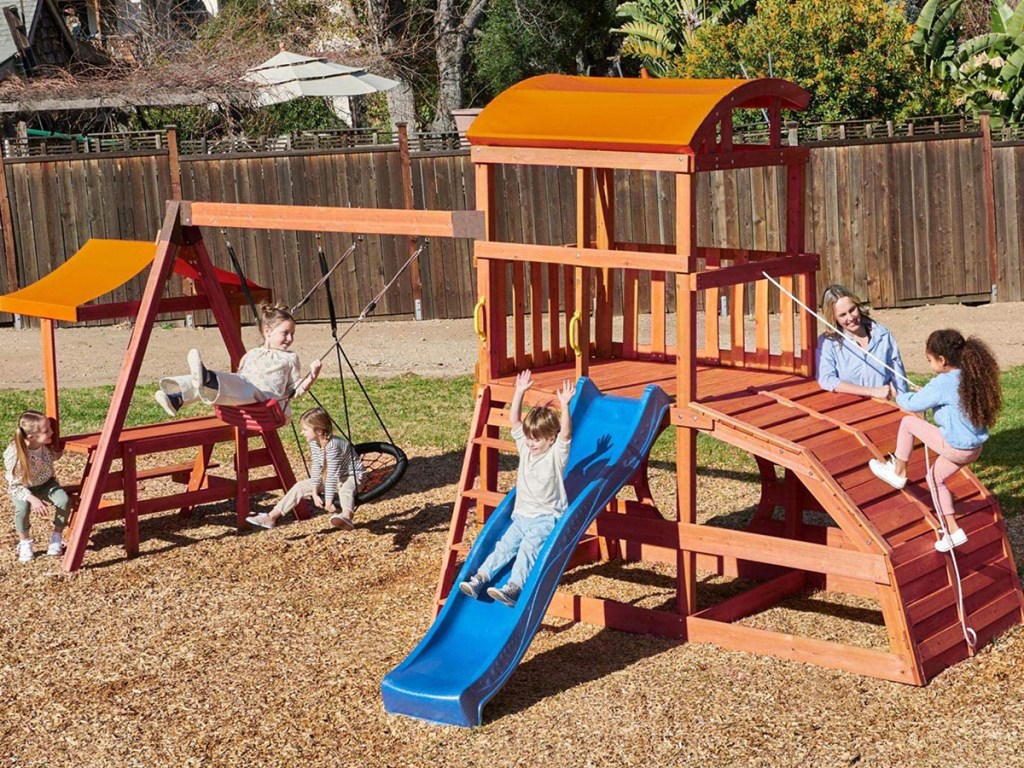 little tykes wooden swing set with kids playing