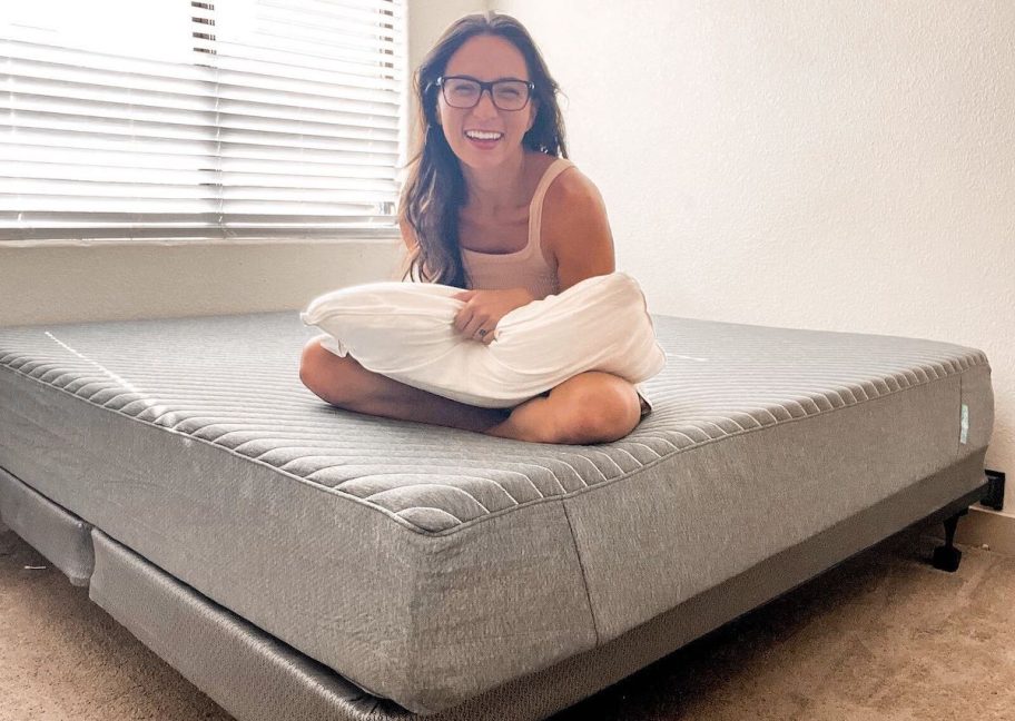 woman sitting on siena mattress in a box 