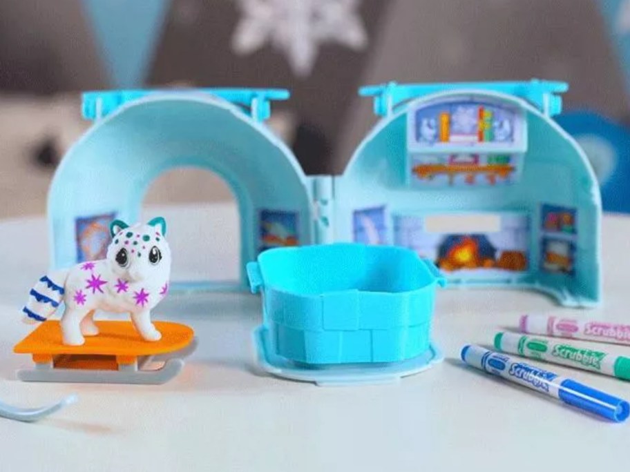 a kid's activity set with an igloo toy that's open and small animals and Crayola markers