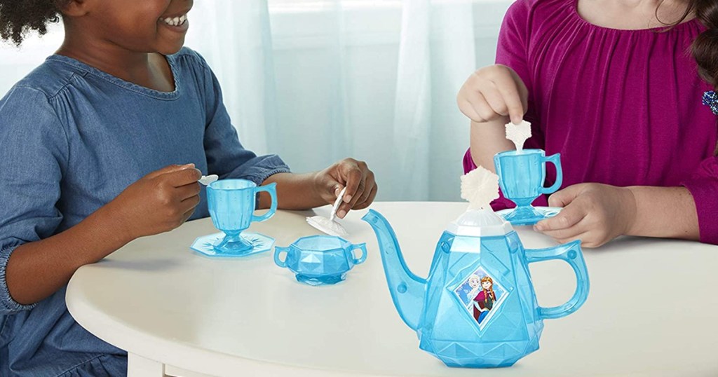 girls playing with frozen tea party set