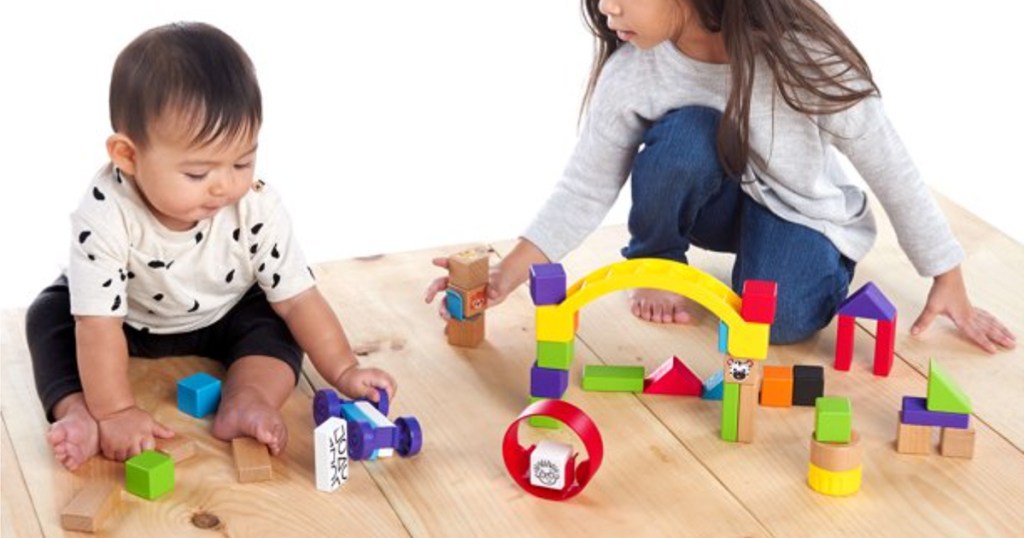 two kids playing with wooden block set