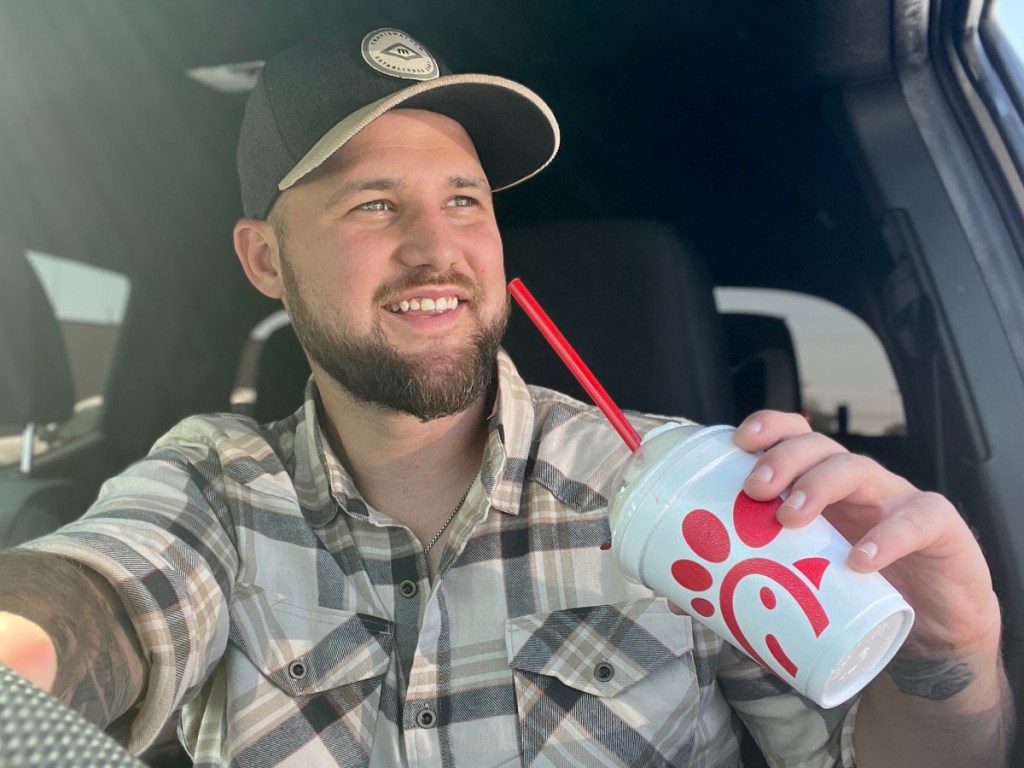 man sitting in car with Chick-fil-A milkshake