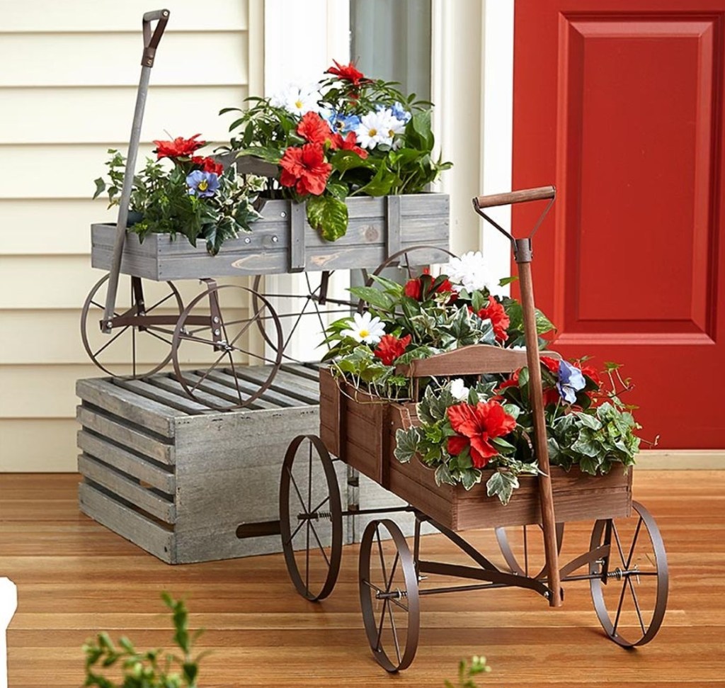 Two wagon planters on a patio with flowers in them