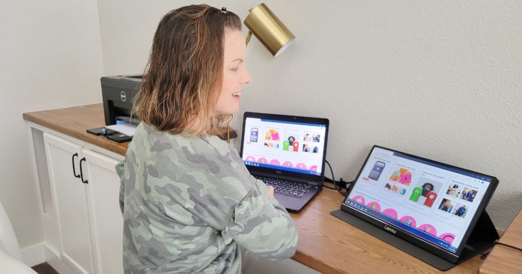 woman sitting at desk with two monitors