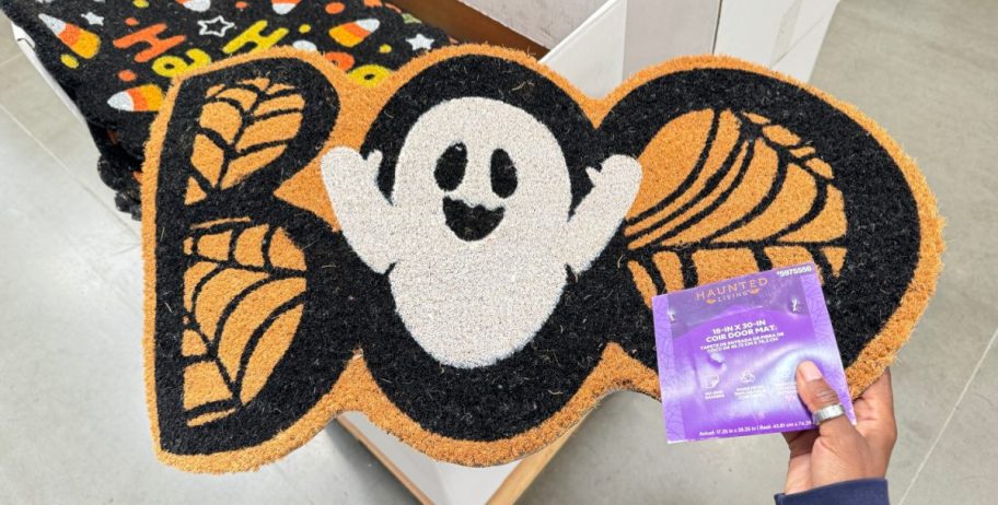 Hand holding a Halloween Doormat from Lowe's in the shape of a ghost