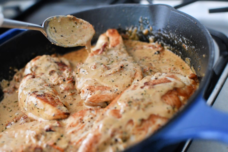 adding cream sauce to sun-dried chicken