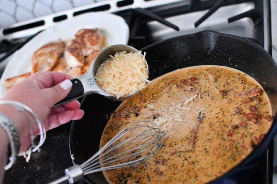 adding parmesan cheese to cream sauce