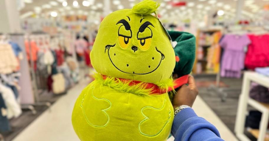 hand holding grinch pillow and blanket 