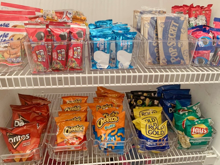 clear bins on shelves with chips and snacks inside them