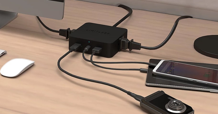 black charger charging camera, and phones on table