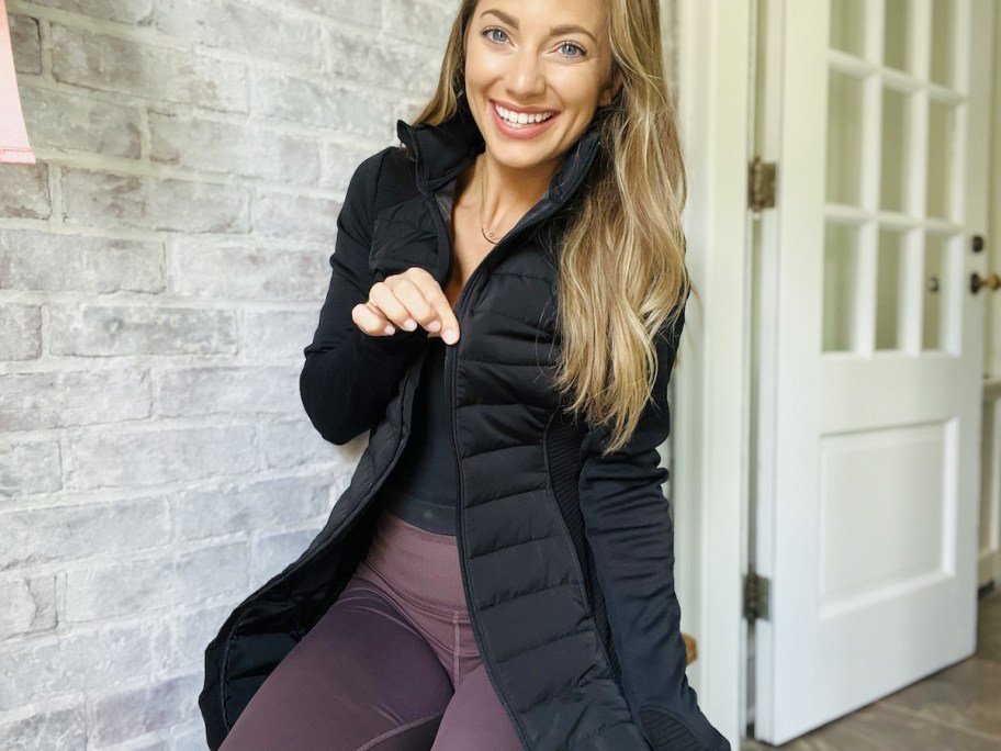 woman smiling pulling at zipper on parka jacket