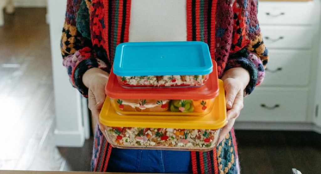 woman holding 3 piece glass storage by Macys