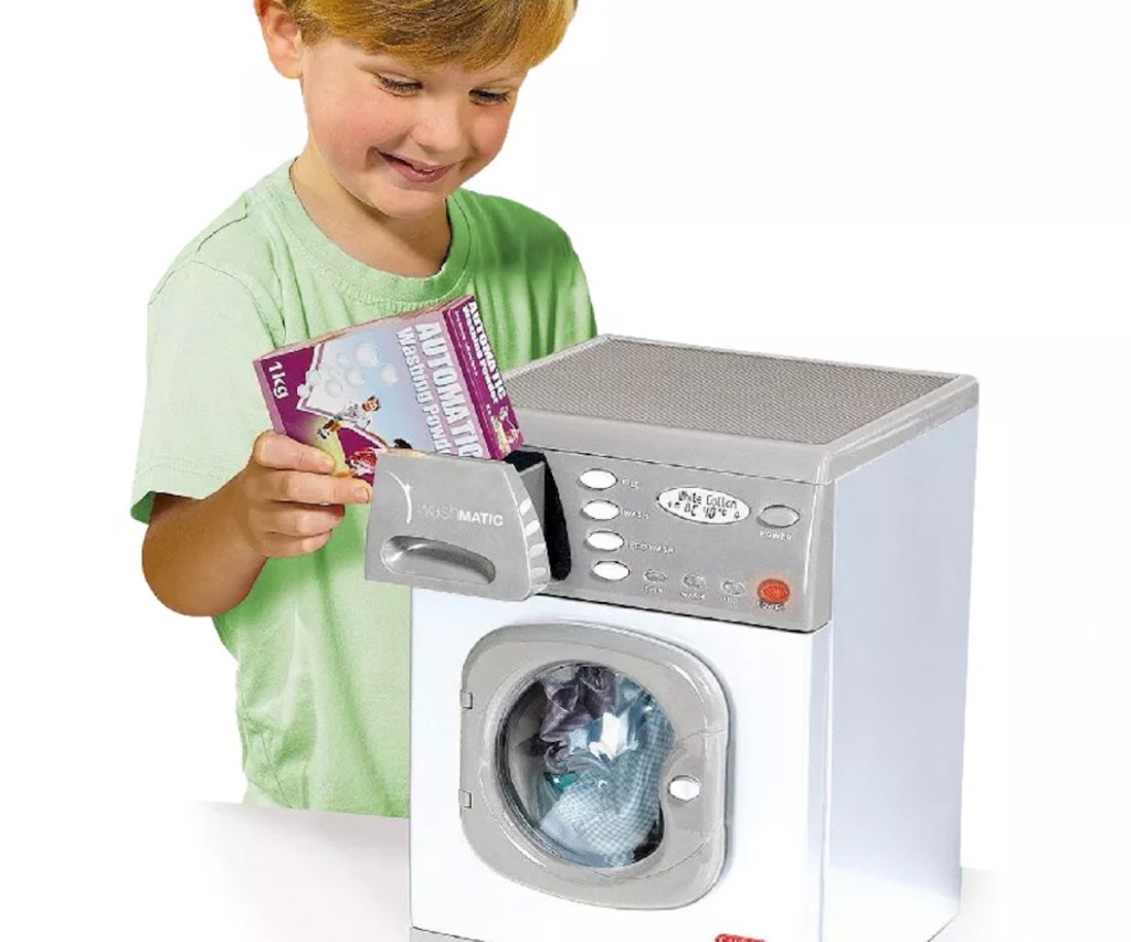 Boy playing with toy washing machine