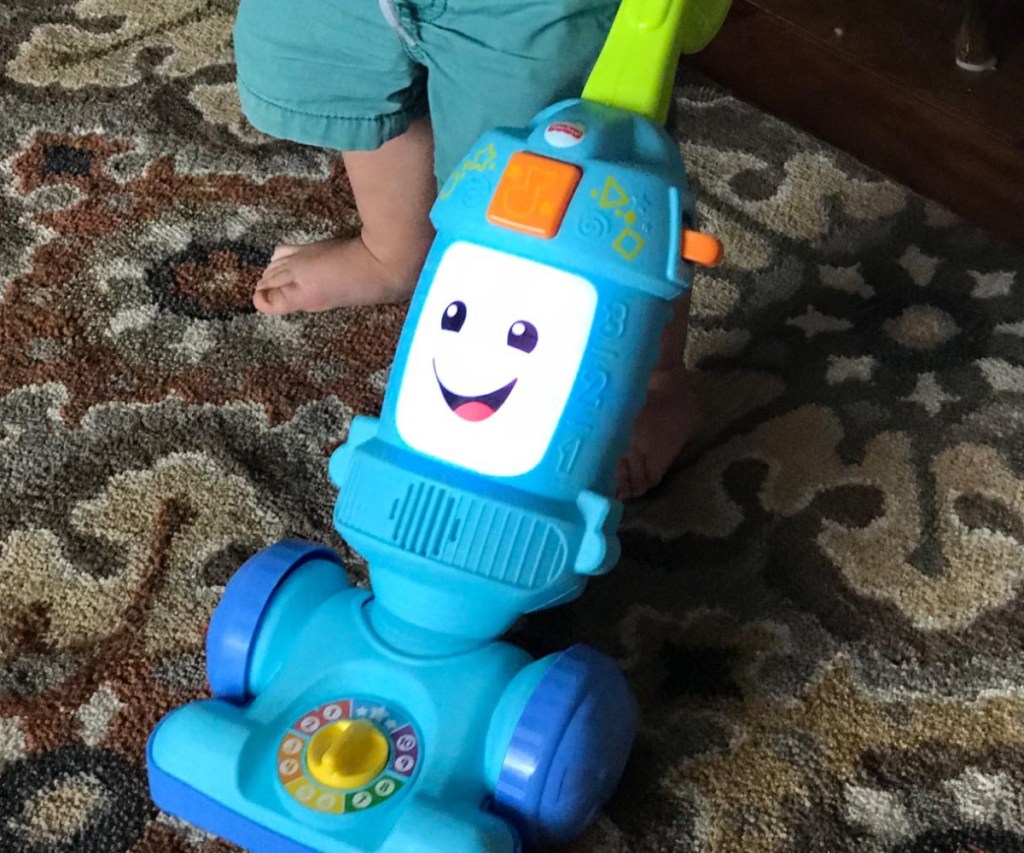 Boy pushing Fisher Price Vacuum