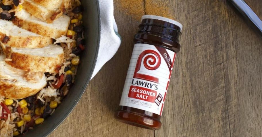 bottle of Lawry's Seasoned salt with some spilling out next to a pot of food