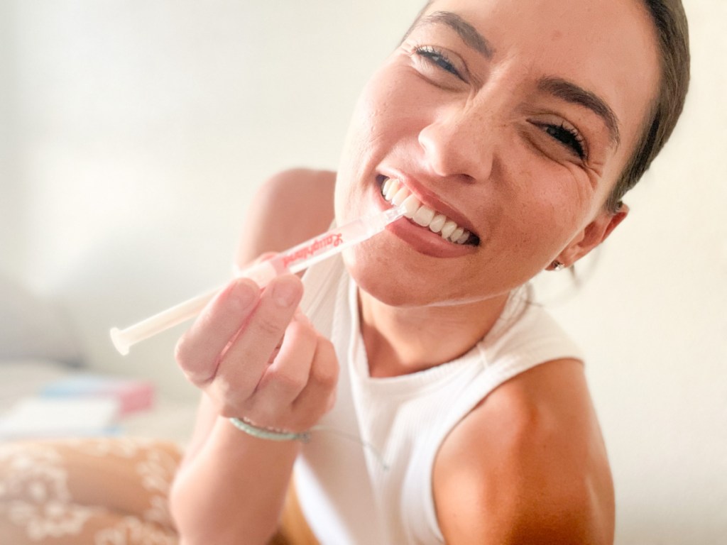 Woman using teeth whitener