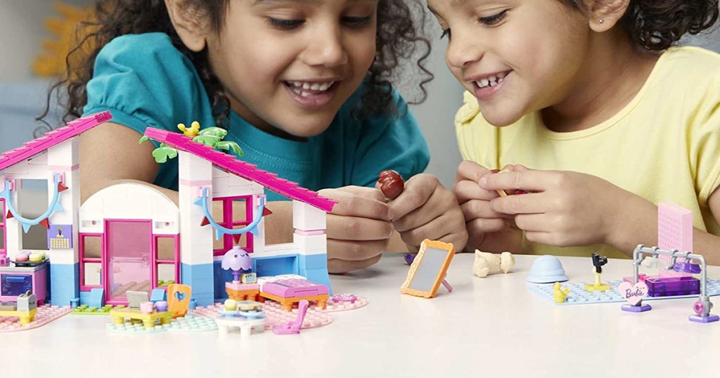 two girls playing with barbie building set