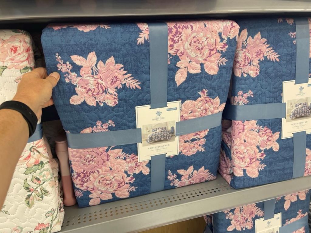 Hand holding a blue floral quilt