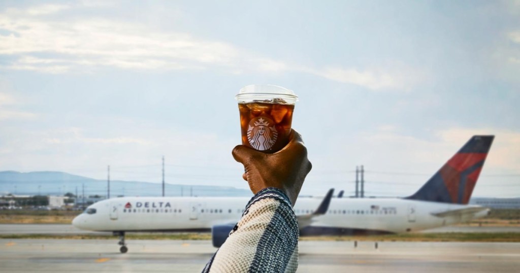 holding an iced Starbucks at the airport