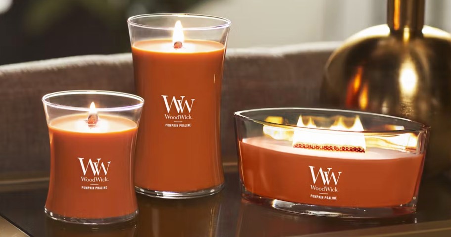 3 lit orange candles on a table