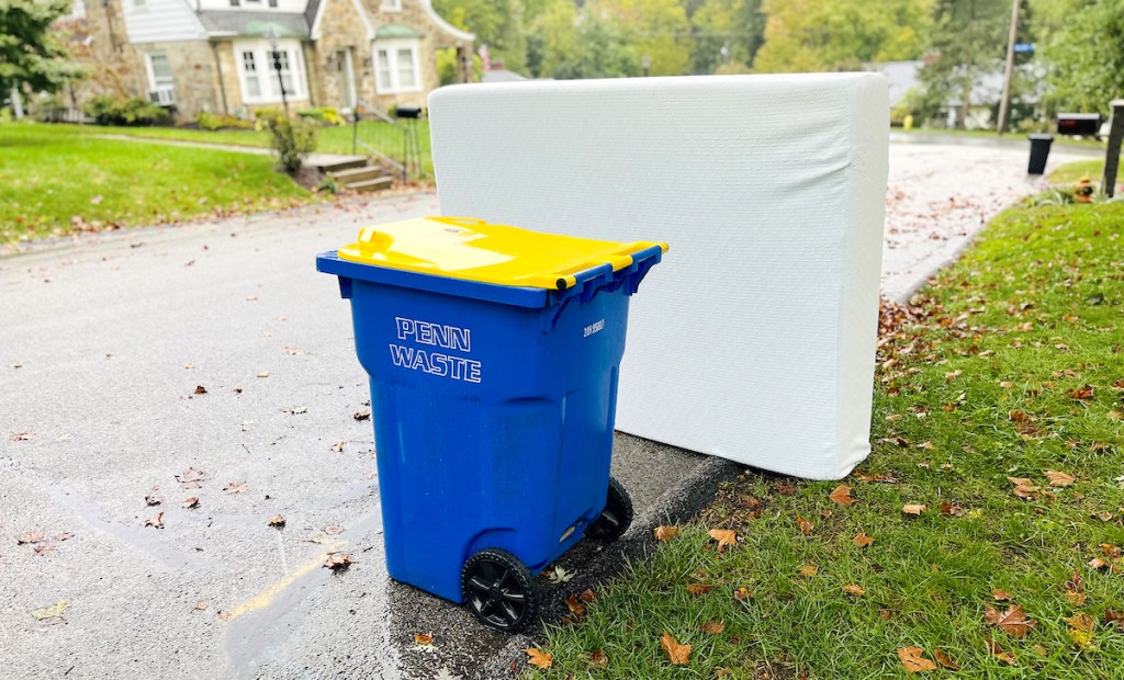 recycling bin and mattress outside on curb for bulk trash day