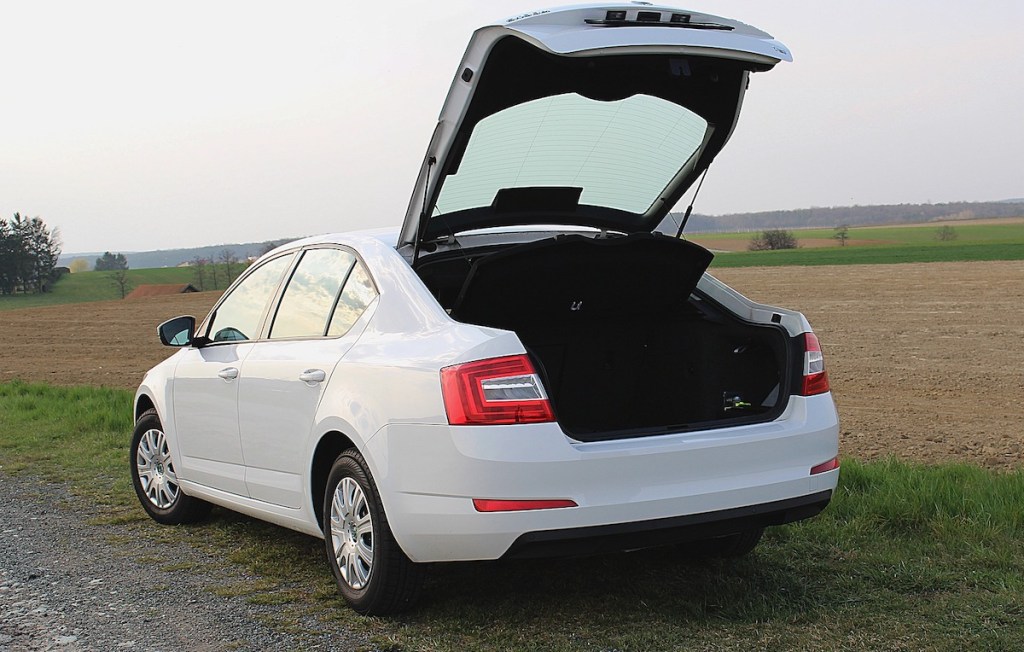 white car parked on country road with trunk open