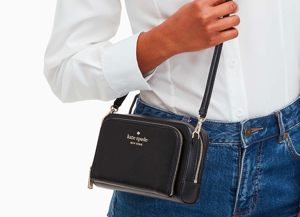 woman in white shirt holding black kate spade purse