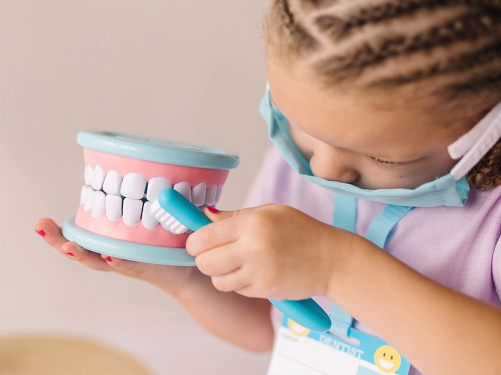 girl playing with dentist toy