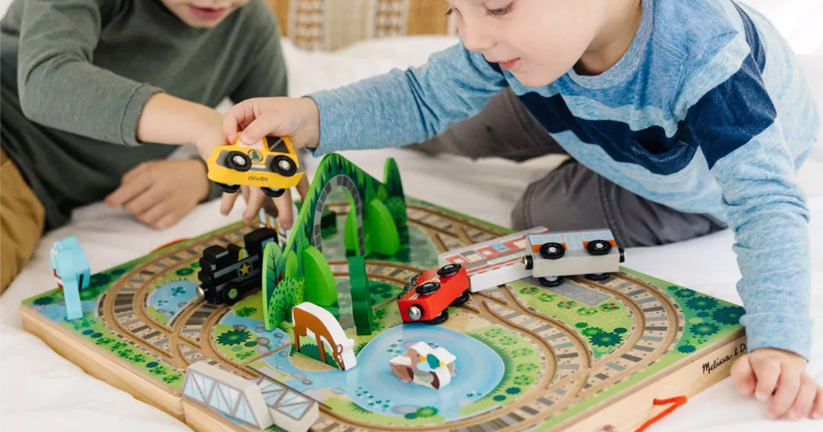 two young boys playing with the melissa & doug take along railway train play set