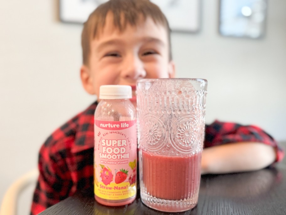 boy behind glass of smoothie