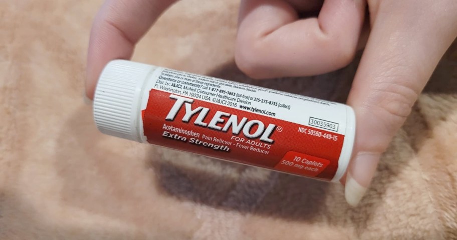 holding a trave-size vial of Tylenol