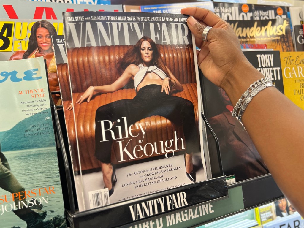 hand taking vanity fair magazine of shelf