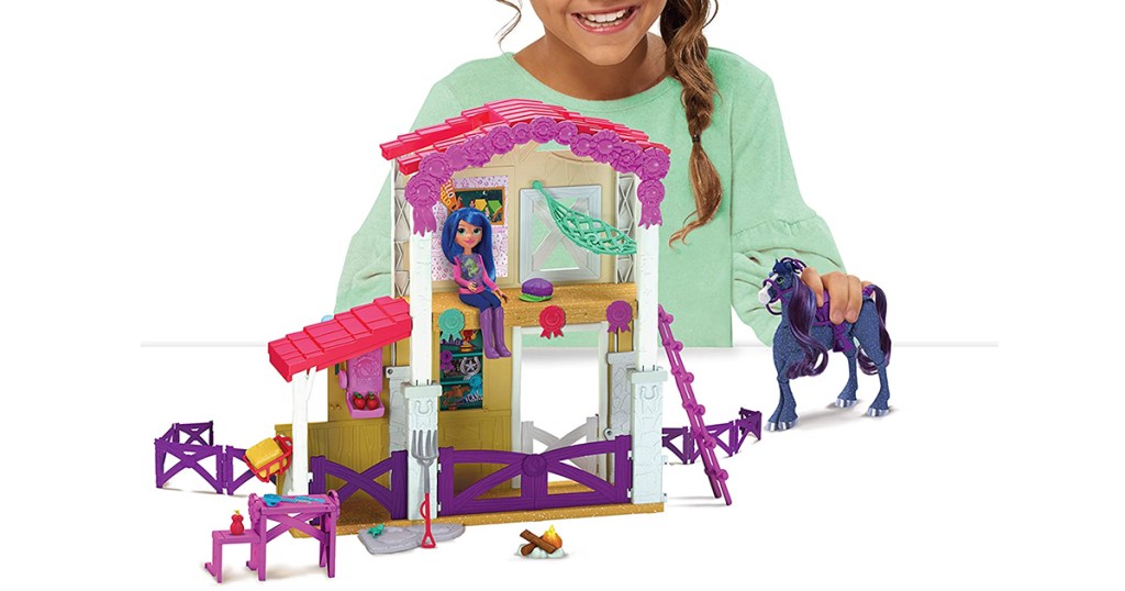 girl playing with winners stable toy