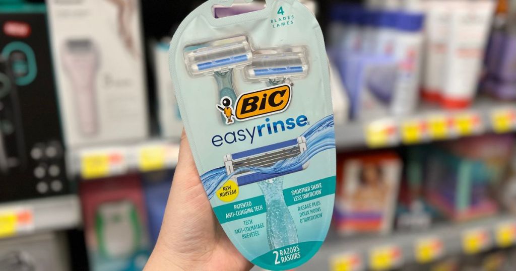 Hand holding up a pack of Bic easy rinse razors