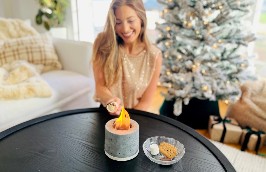 woman making smores on indoor personal fireplace