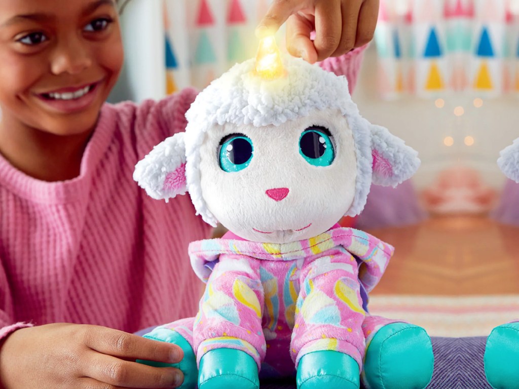 girl playing with FurReal Sweet Jammiecorn Lamb Interactive Plush Toy