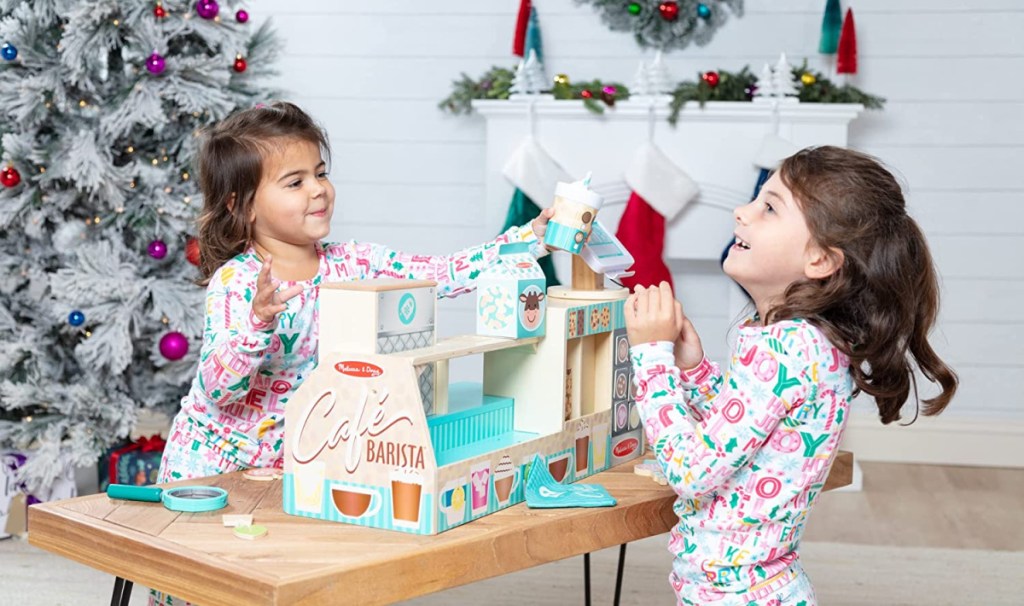 little girls playing with a Melissa & Doug Wooden Café Barista Coffee Shop