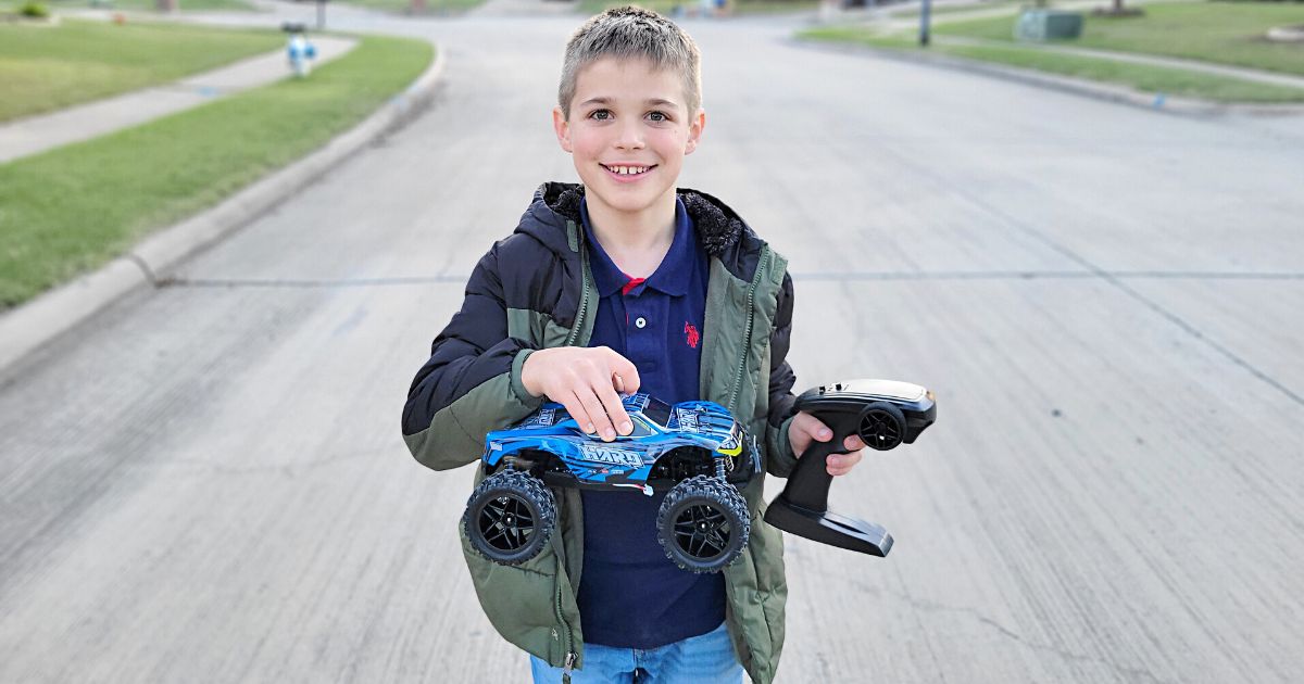 boy holding blue monster truck